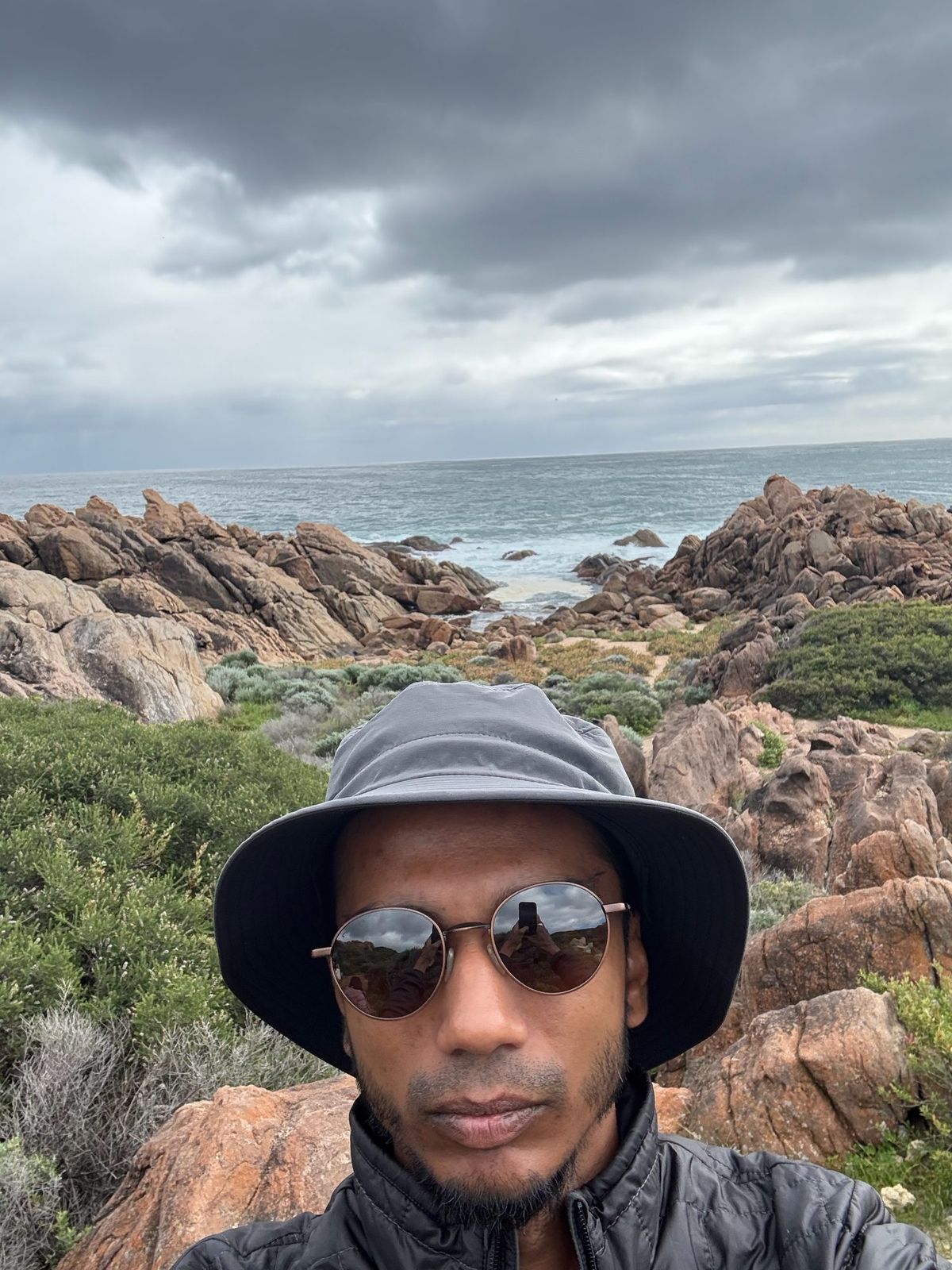 Vinesh Sinha on a rocky coastline under a stormy sky