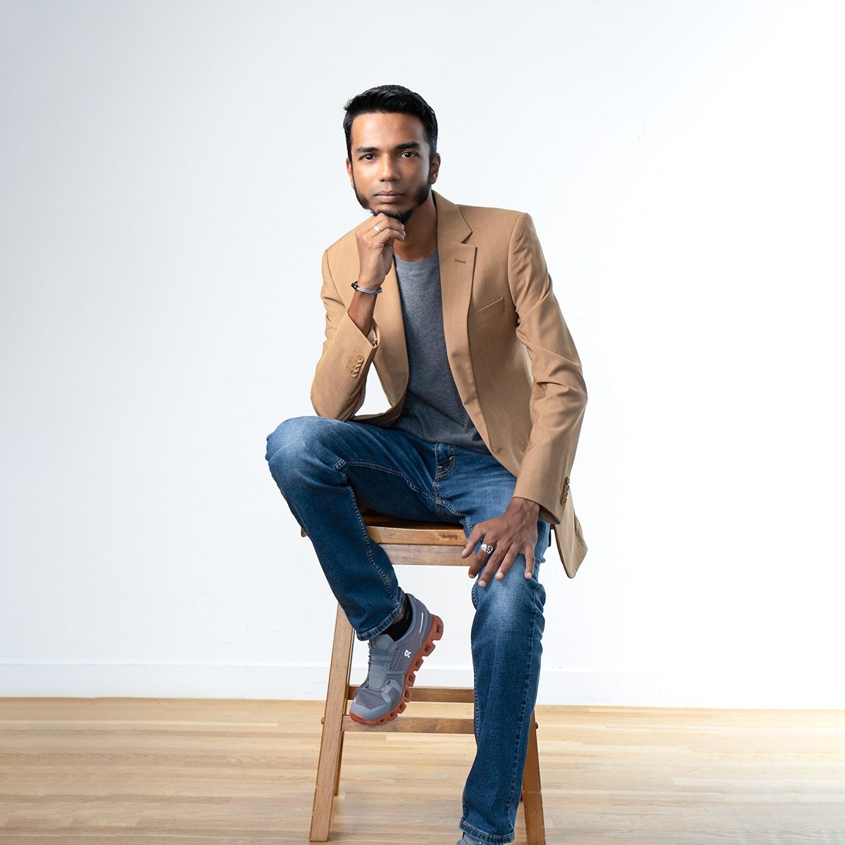 Vinesh Sinha seated in a tan blazer